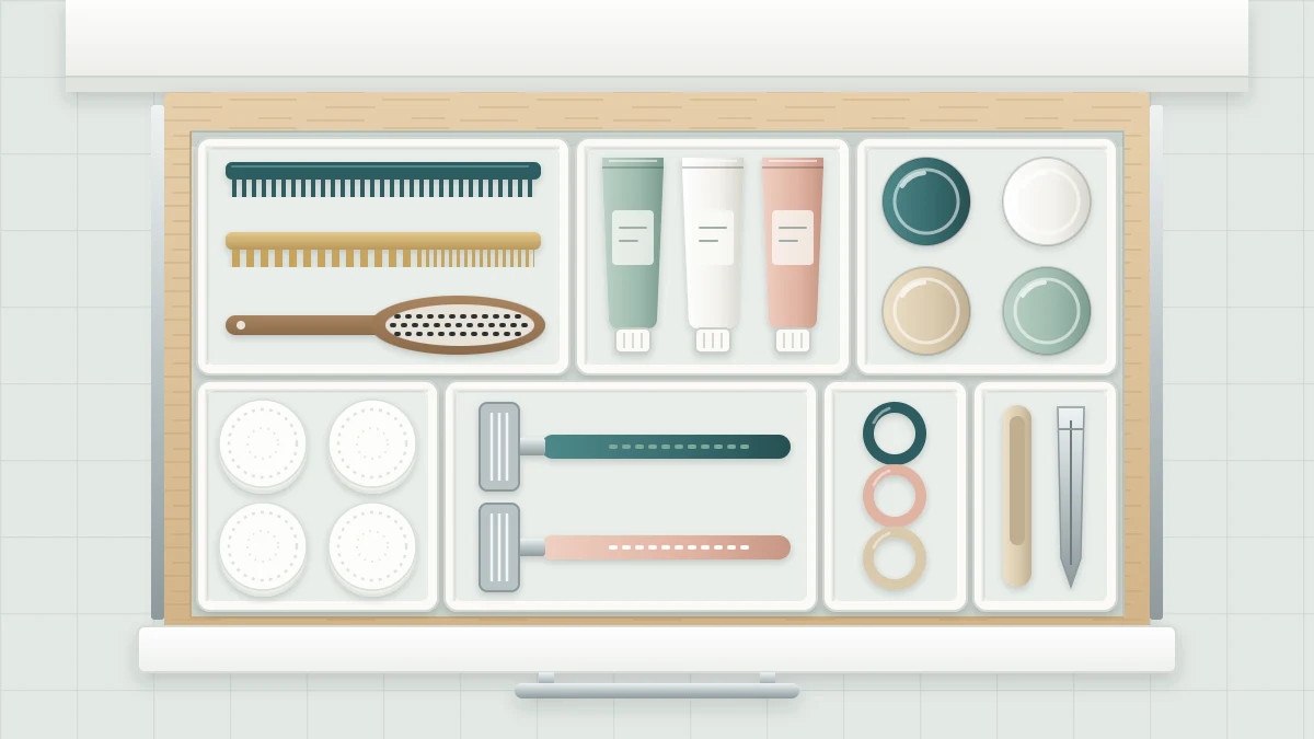 Top view of an open bathroom drawer fitted edge to edge with modular trays, each holding one kind of item such as combs, tubes and small jars