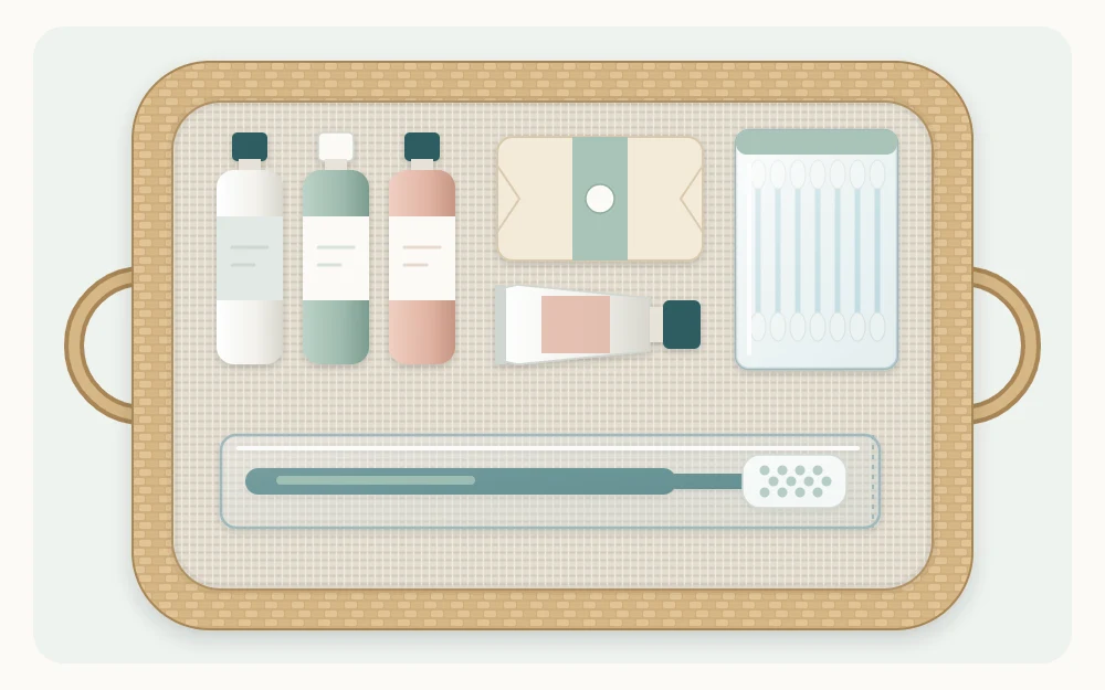 An open basket seen from above with travel-size bottles, a wrapped bar of soap, a sleeved toothbrush and a pack of cotton swabs