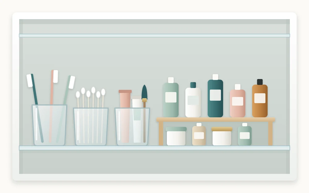 One cabinet shelf with small items grouped in three clear cups and a low riser lifting a second row of bottles