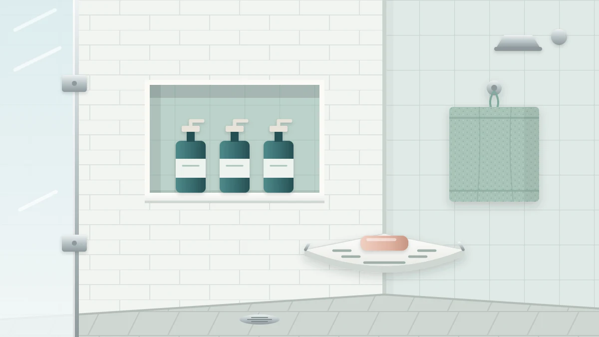 A tiled shower corner with a recessed niche holding three matching bottles, a slotted corner shelf with soap and a washcloth on a hook