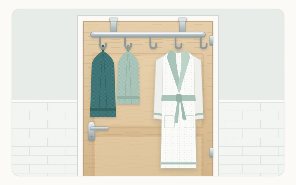 The inside face of a bathroom door with an over-the-door rack of five hooks holding two towels and a robe